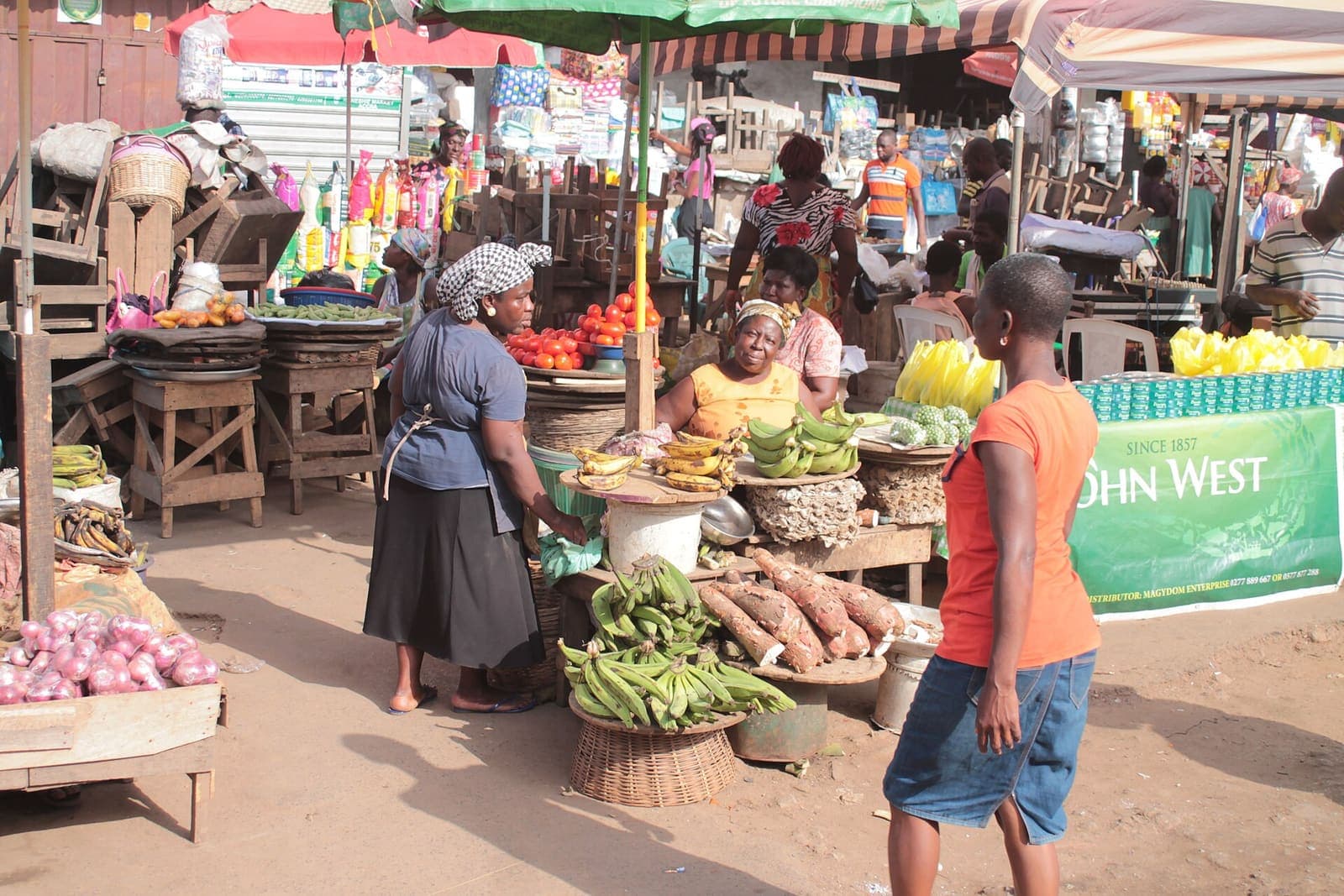 Traders selling cassava, plantain and tomatoes at an open-air market in Ghana.